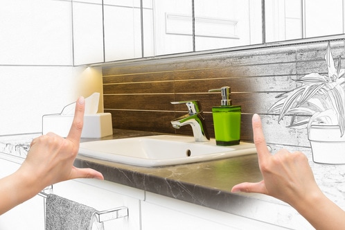 Picture of hands lining up where a sink should go for a bathroom remodel.